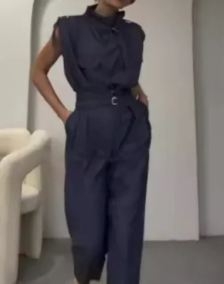 A woman wearing a beige waist-slimming belt blouse with shoulder-slimming design and matching pants.