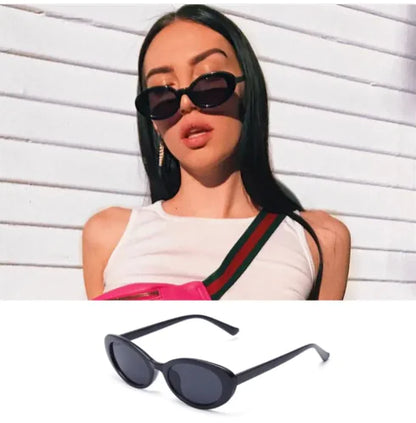A woman in a white sleeveless top and carrying a pink bag wears Retro Oval Sunglasses in black, standing before a white wall. A close-up below highlights the same Retro Oval Sunglasses style.