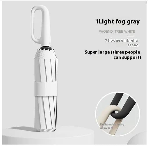 A white umbrella with a ring buckle, standing on a white surface, with a close-up inset showing the texture of the umbrella's fabric.