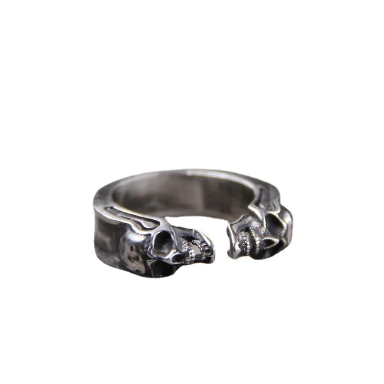 A 925 Thai silver ring with an engraved skull design, displayed on a textured surface.