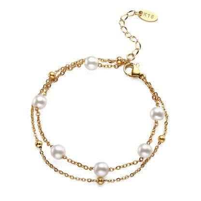 A two-tone (gold and silver) bracelet with geometric shape design and pearl inlays, displayed against a white background