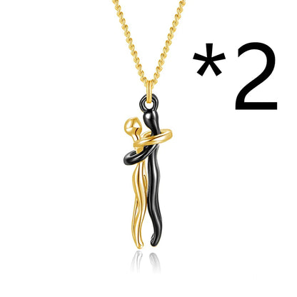 A pendant necklace featuring two figures in a hugging embrace, with the necklace chain visible at the top of the image. The main object is marked with an asterisk.