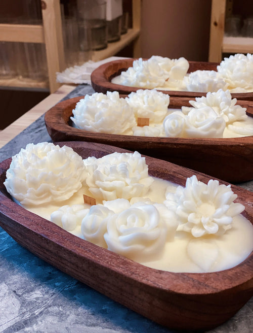 Wooden bowl candles with floral designs on top, made of natural soy wax with wooden and cotton wicks.
