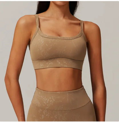 A woman wearing a beige sports bra with a bronzing cloud pattern.
