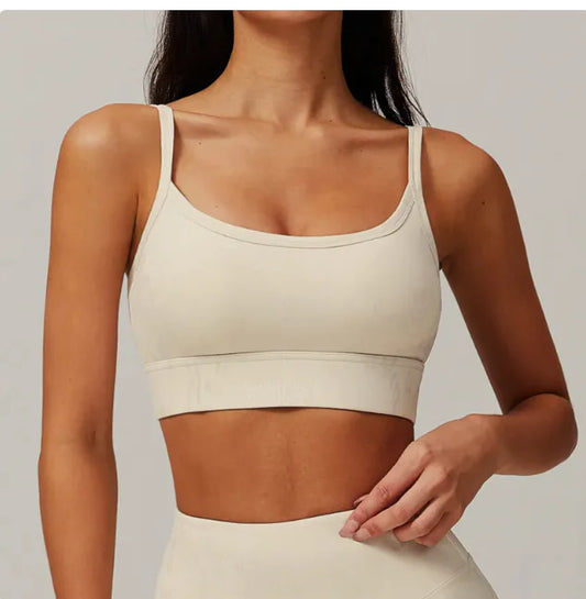 A woman wearing a beige sports bra with a bronzing cloud pattern.