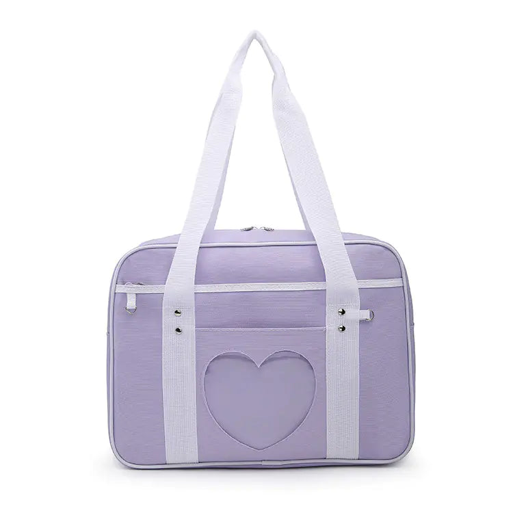 A blue shoulder tote bag with a white heart pattern on the front, featuring white straps and a zipper closure.