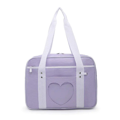 A blue shoulder tote bag with a white heart pattern on the front, featuring white straps and a zipper closure.