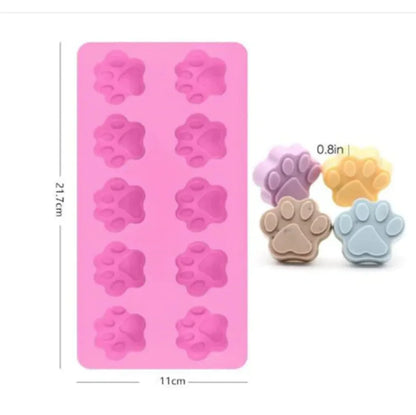 A silicone cake mold featuring shapes for dino bones, with two colors shown: purple and pink.