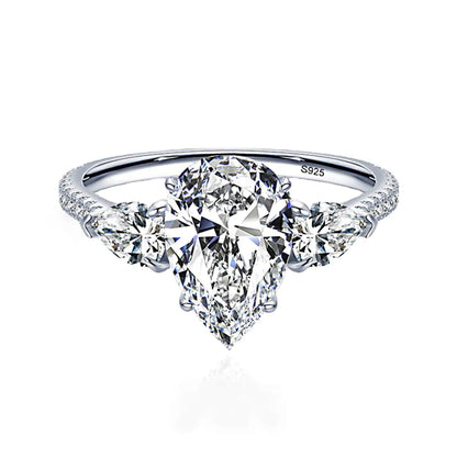 A sterling silver ring with a drop-shaped purple diamond centerpiece and accent diamonds around it.