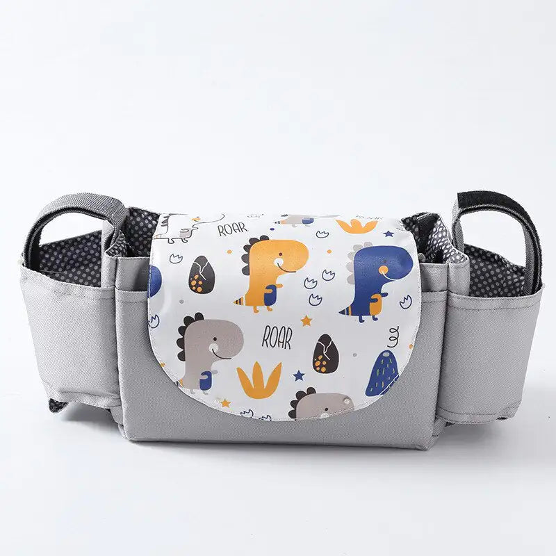 Gray diaper bag with dinosaur-themed pocket on a white background