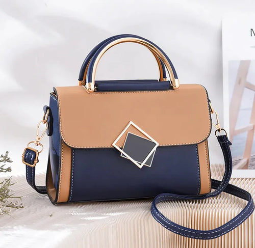 A two-tone elegant sling bag with blue and beige colors, featuring a leather-like texture, a structured design, and a metallic buckle.
