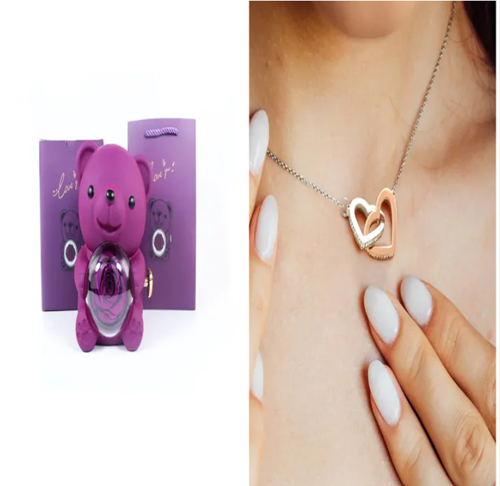 A teddy bear gift box in blue with a preserved rose and a necklace, alongside a rotating rose jewelry box, against a white background.