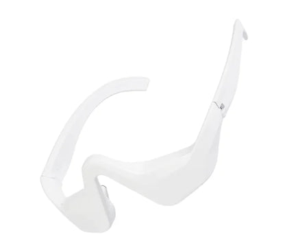A white, sleek eye bag remover device with a curved design for the under-eye area.