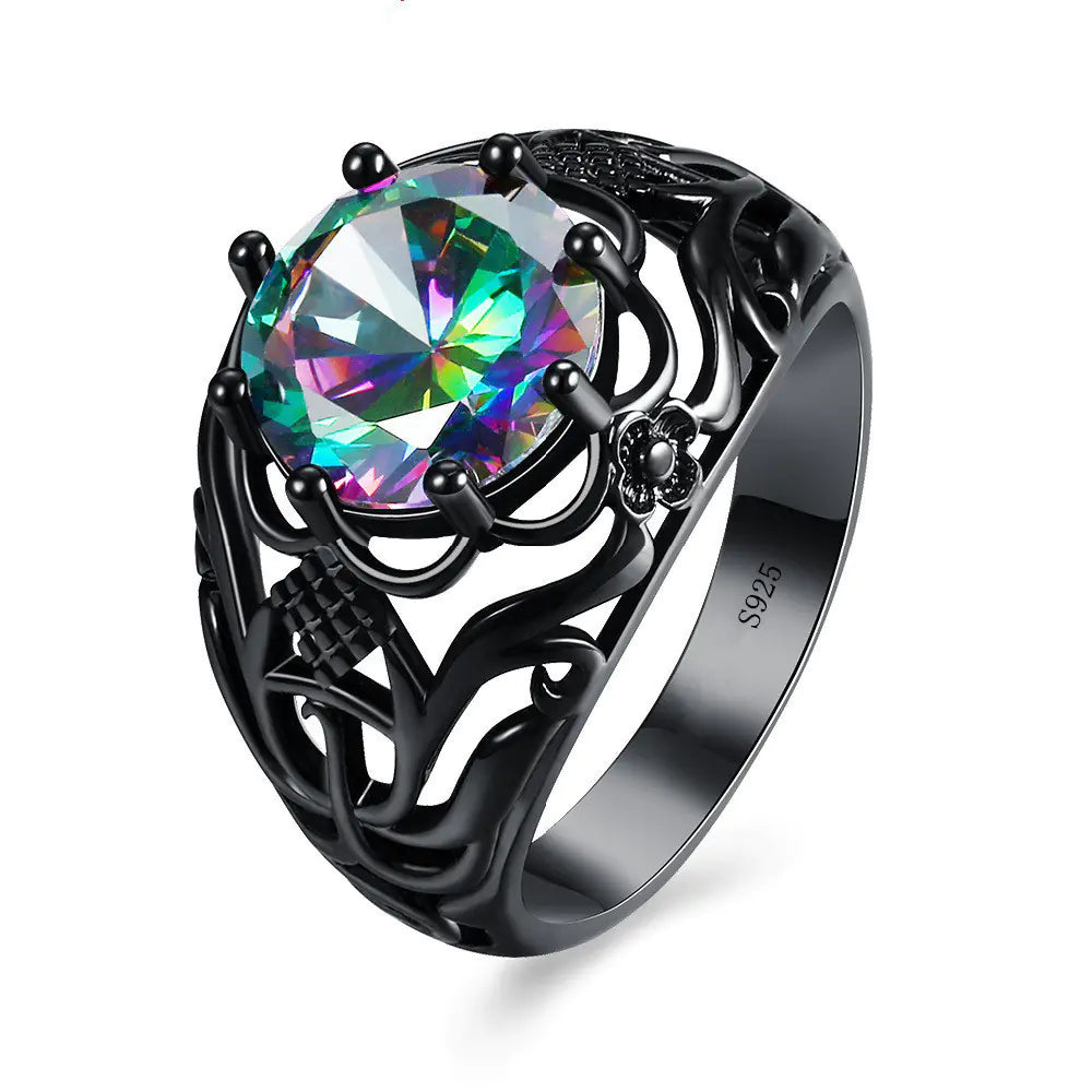 A woman's hand displaying a black gold ring with a hollow design and a purple artificial gemstone in the center.