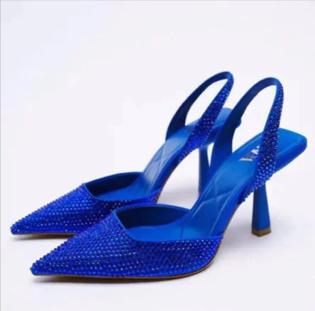 A pair of blue pointed-toe high heels with a textured design on the upper part and stiletto heels.