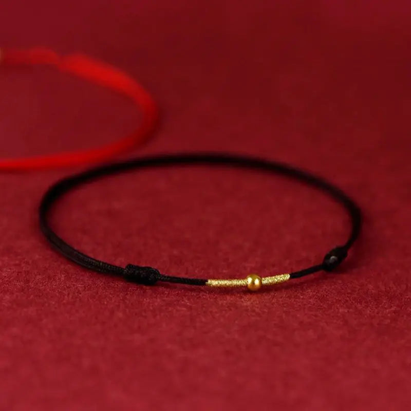 A simple woven hand rope bracelet with a floral shape and multicolored threads on a red background.