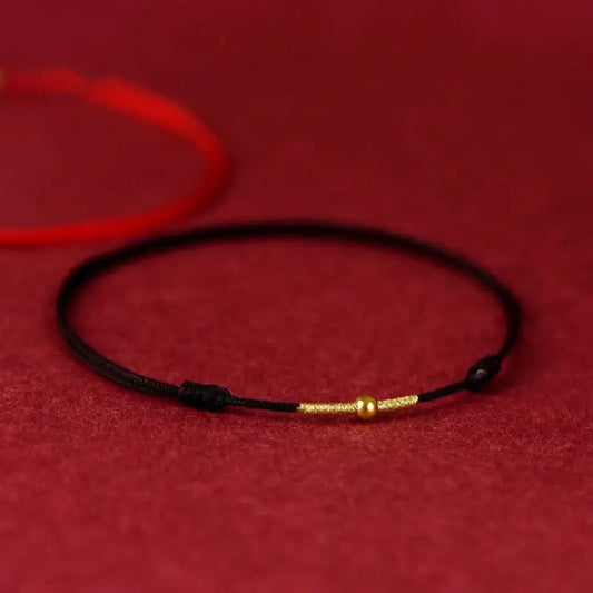 A simple woven hand rope bracelet with a floral shape and multicolored threads on a red background.