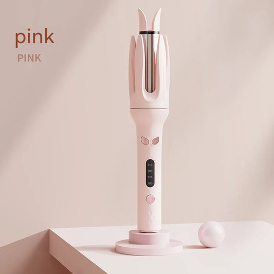 A pink full-automatic hair curler standing upright on a stand with a closed curling chamber, displaying its body and temperature control panel.