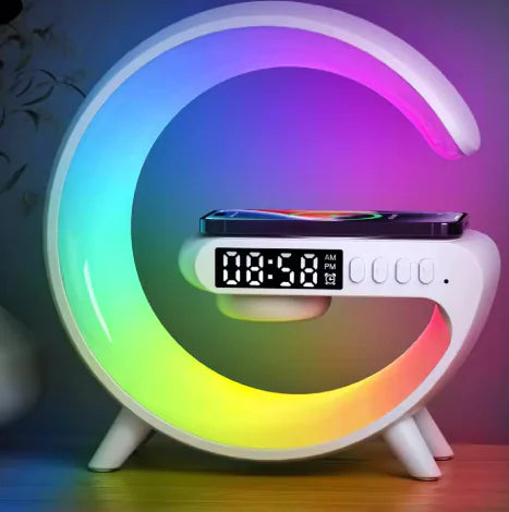 A modern G-shaped lamp with a Bluetooth speaker on top, displaying a colorful RGB light spectrum, next to which an alarm clock is set.