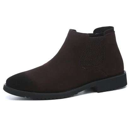 A pair of black high-top leather Chelsea ankle boots with a pointed toe and flat heel.