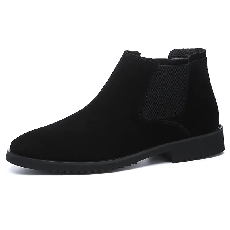 A pair of black high-top leather Chelsea ankle boots with a pointed toe and flat heel.