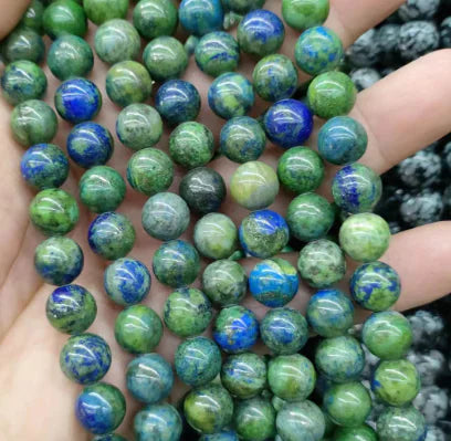 A hand holding round beads with a mix of blue and white colors, part of the Natural Tiger Stone Powder with Amethyst and Lapis collection.