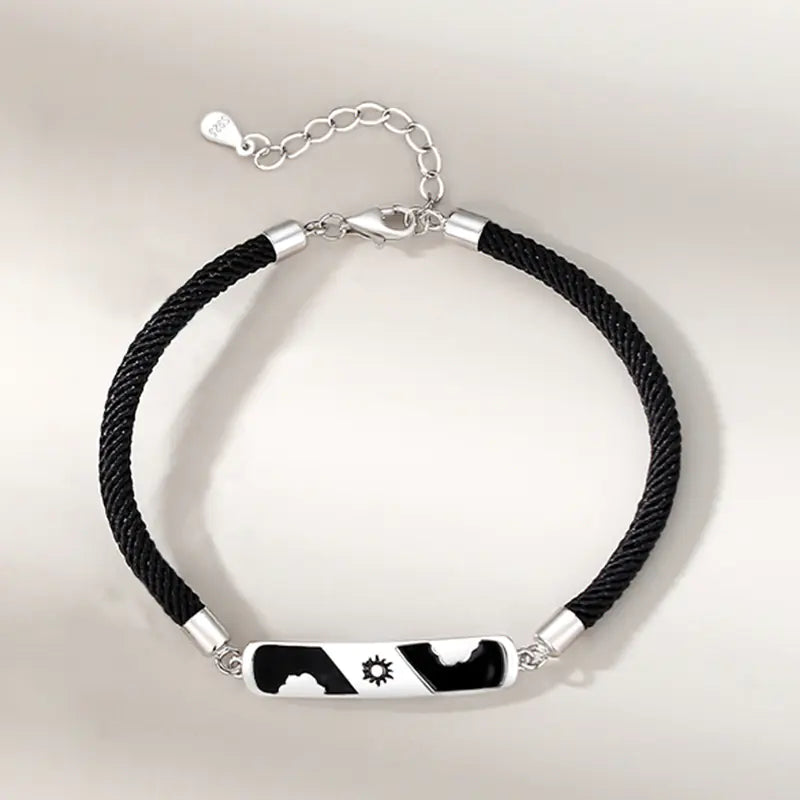 Two sterling silver bracelets, one with a cloud-shaped charm and a blue crystal, and the other with a black and white design featuring a star.