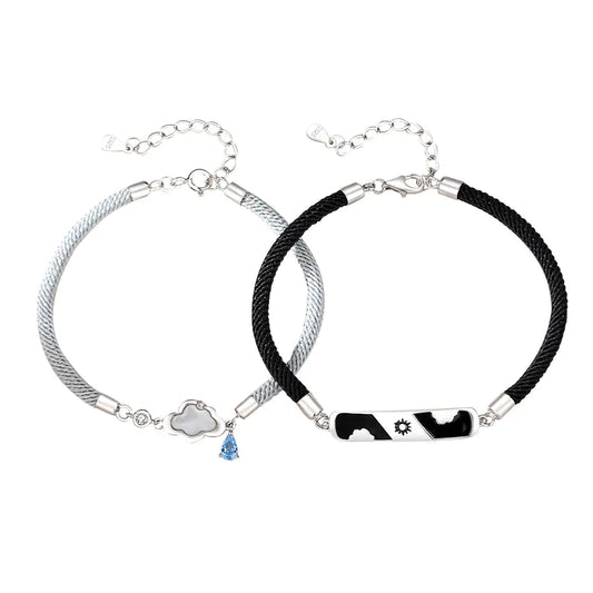 Two sterling silver bracelets, one with a cloud-shaped charm and a blue crystal, and the other with a black and white design featuring a star.