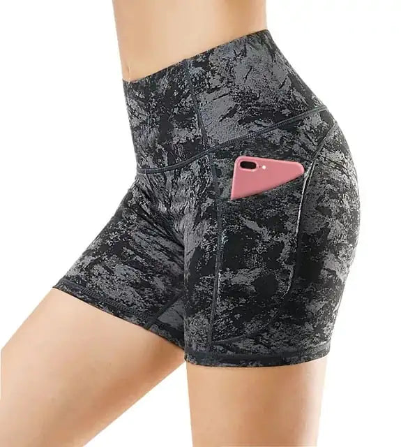 A pair of women's yoga fitness running shorts in a camouflage pattern with a phone pocket on the right side.