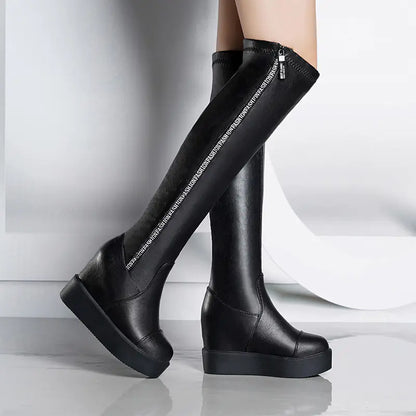 A pair of over-the-knee black wedge heel boots with a side zipper, on a white background.