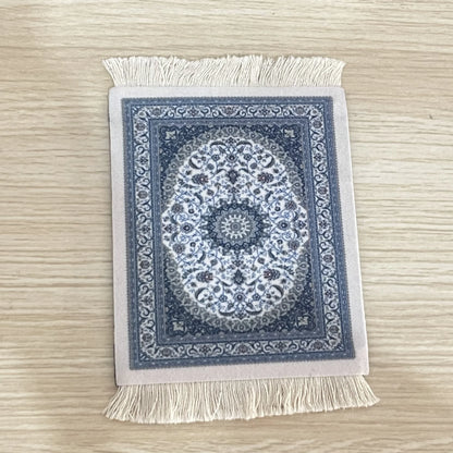 A rectangular mouse pad with a vintage Persian carpet design, featuring a prominent star shape in the center, placed on a textured white surface.