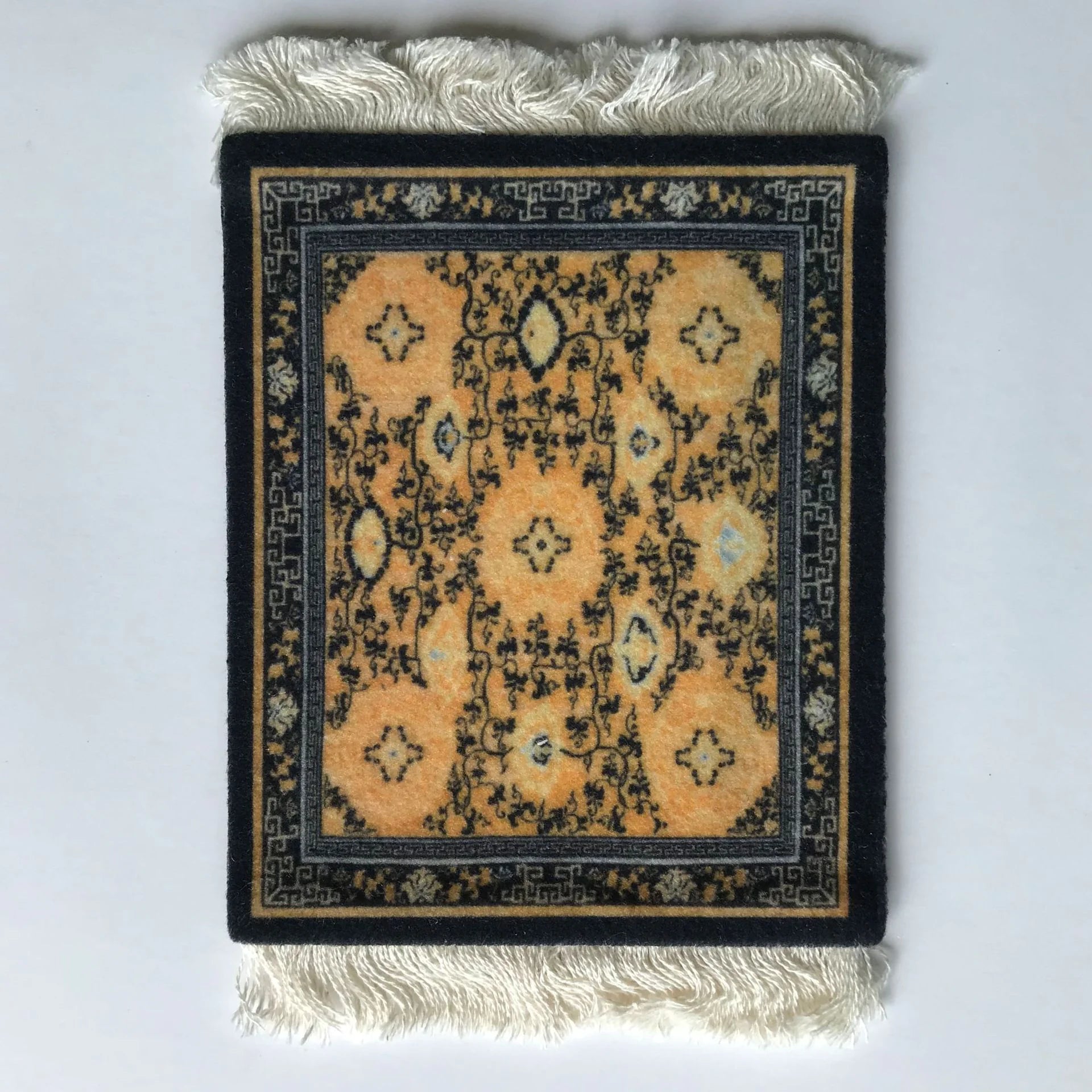 A rectangular mouse pad with a vintage Persian carpet design, featuring a prominent star shape in the center, placed on a textured white surface.