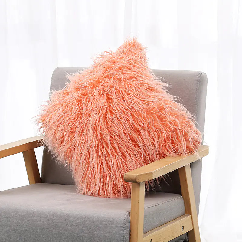 A white plush cushion cover with a long wool-like texture, displayed on a gray armchair.