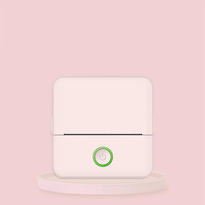 A compact portable thermal printer with a white body and a green power button, displayed against a pink background.