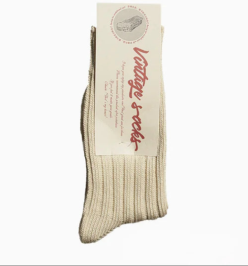 A pair of beige alpaca wool socks with the brand label showing the name 'Alpaca socks' and some additional text.
