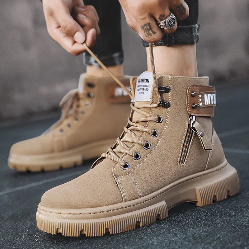 A pair of beige high-top Martin boots for men with lace-up closure, displayed against an urban backdrop.