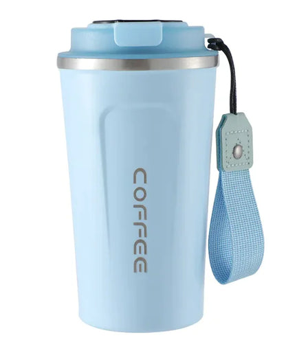 A white stainless steel vacuum coffee cup with a lid and a carrying strap, placed on a wooden surface with coffee beans scattered around it.