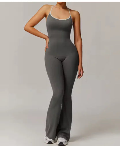 A woman wearing a solid gray long pants jumpsuit with a beauty-back design.