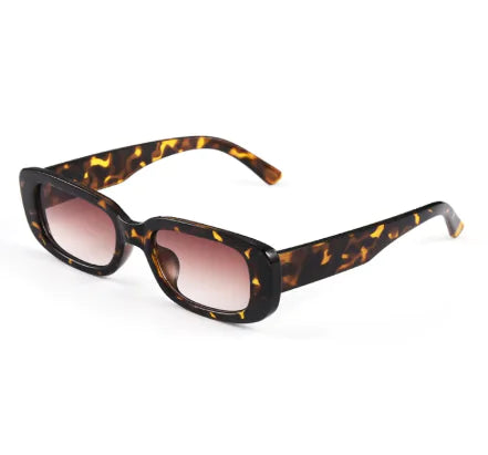 A pair of square-shaped sunglasses with a sleek frame design, featuring pink lenses and a transparent frame.