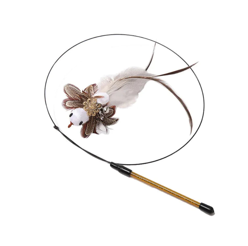 A cat teaser wand with a long steel wire rod and a feather attachment at the end, with a small bell and decorative flower.
