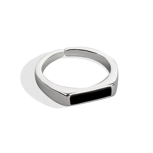 A sterling silver ring with a black insert and a platinum finish, displayed on a white background.