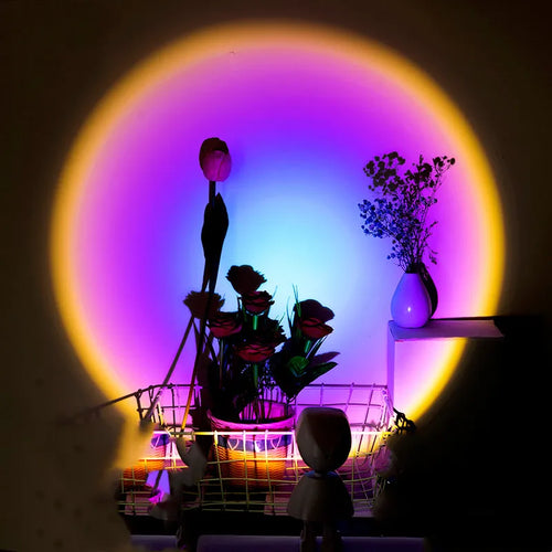 A sunset night light atmosphere lamp with a projection of a golden sunset on a wall, featuring an astronaut figure and illuminating a shelf with flowers and a microphone.
