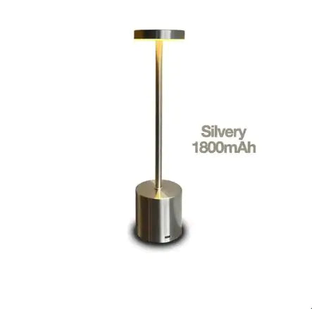 An LED table lamp with a modern touch sensor control, adjustable brightness, and a cylindrical base. The lamp is silver-colored, and its battery capacity is labeled as 1800mAh.