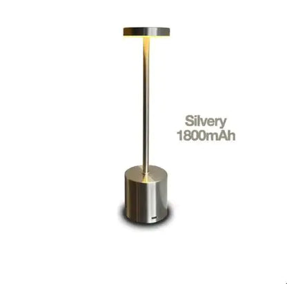 An LED table lamp with a modern touch sensor control, adjustable brightness, and a cylindrical base. The lamp is silver-colored, and its battery capacity is labeled as 1800mAh.