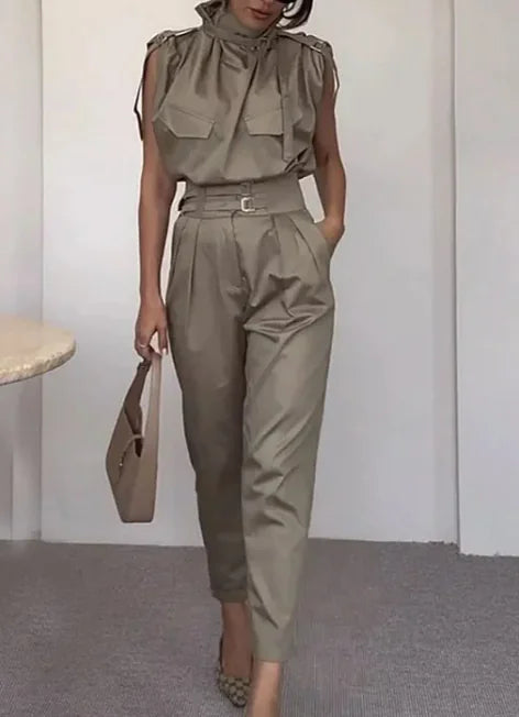A woman wearing a beige waist-slimming belt blouse with shoulder-slimming design and matching pants.