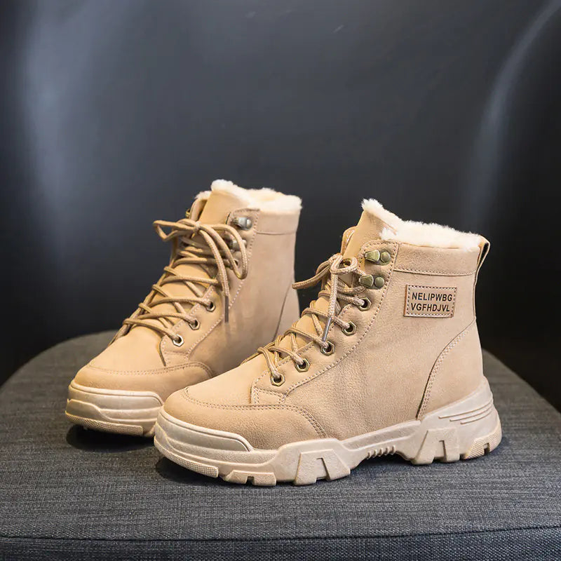 A pair of beige, short snow boots with lace-up closure and a flat heel, designed for women.