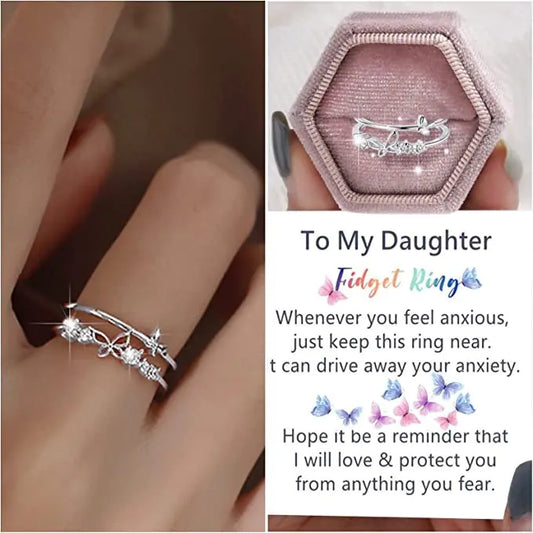 A silver-colored double layer butterfly diamond ring set displayed on a pink cushion, with an offer message to a daughter.